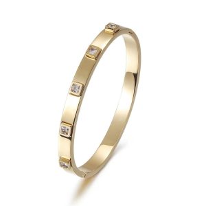 Elegant gold metal hinged bangle with embedded stones for women.