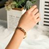 Elegant metal stone hinged bangle bracelet on a woman's wrist.