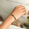 Elegant metal stone hinged bangle on a woman's wrist for stylish jewelry.