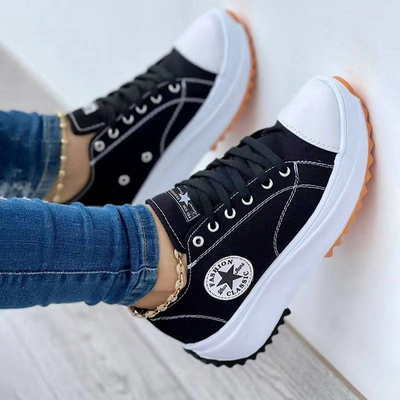 Stylish black and white sneakers with orange sole for casual wear.