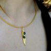 Elegant olive leaf pendant necklace in gold brass with black rhodium accents.