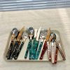 Colorful eco-friendly cutlery set with spoons, forks, and knives on a tray.
